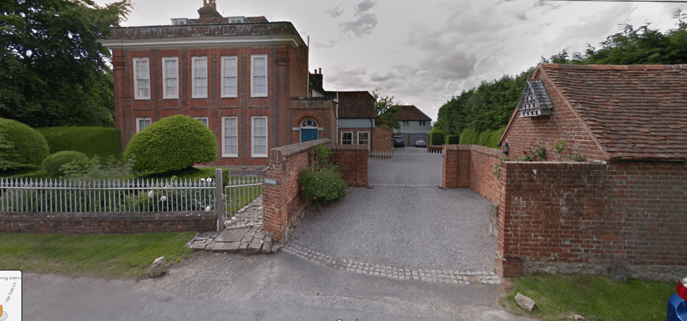 A grand country house and its adjoining outbuildings has a mix of fences. Outside the house is a low-level brick wall with decorative cast iron. The outbuildings are screened by a high-level brick wall with high, cast-iron gates that match the railings in front of the house